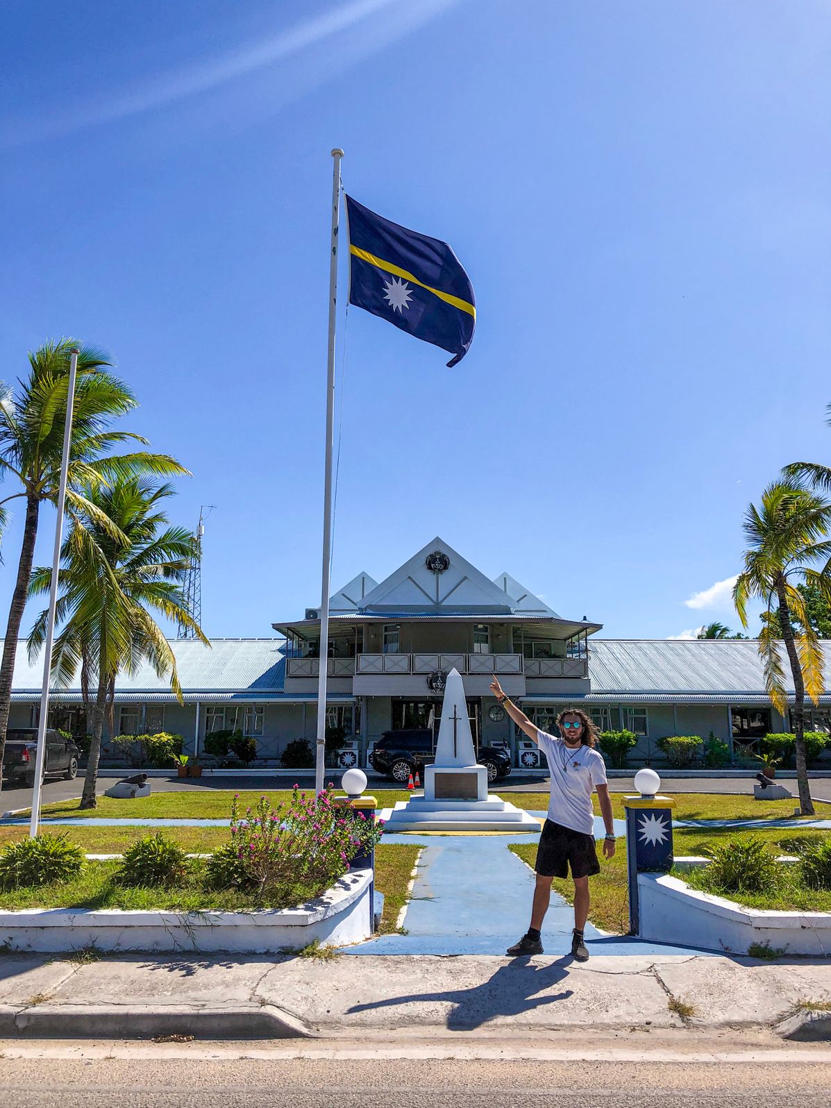 me pointing at the flag of Nauru in front of the Parliament building